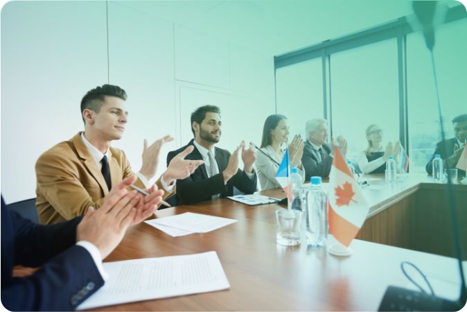 Politikusok tapsolnak egy tárgyalóteremben tartott megbeszélésen
